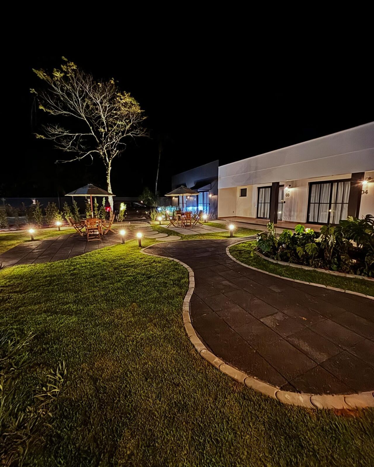 Jardim da Pommerlofts com caminhos iluminados à noite